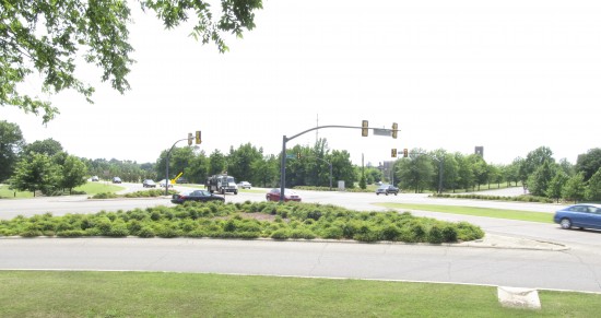 Access to and from this divided highway creates a forbidding intersection for pedestrians at one of the main entrances to Mississippi State University. There are signal request buttons, but to reach the traffic islands pedestrians must first venture across right-turn lanes without stop signs. The arrow indicates one of four pushbuttons. Concepts for making this intersection more pedestrian-friendly have been developed, but there are no immediate plans to change the situation.